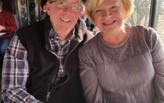 Tony Shuler sitting down smiling with woman
