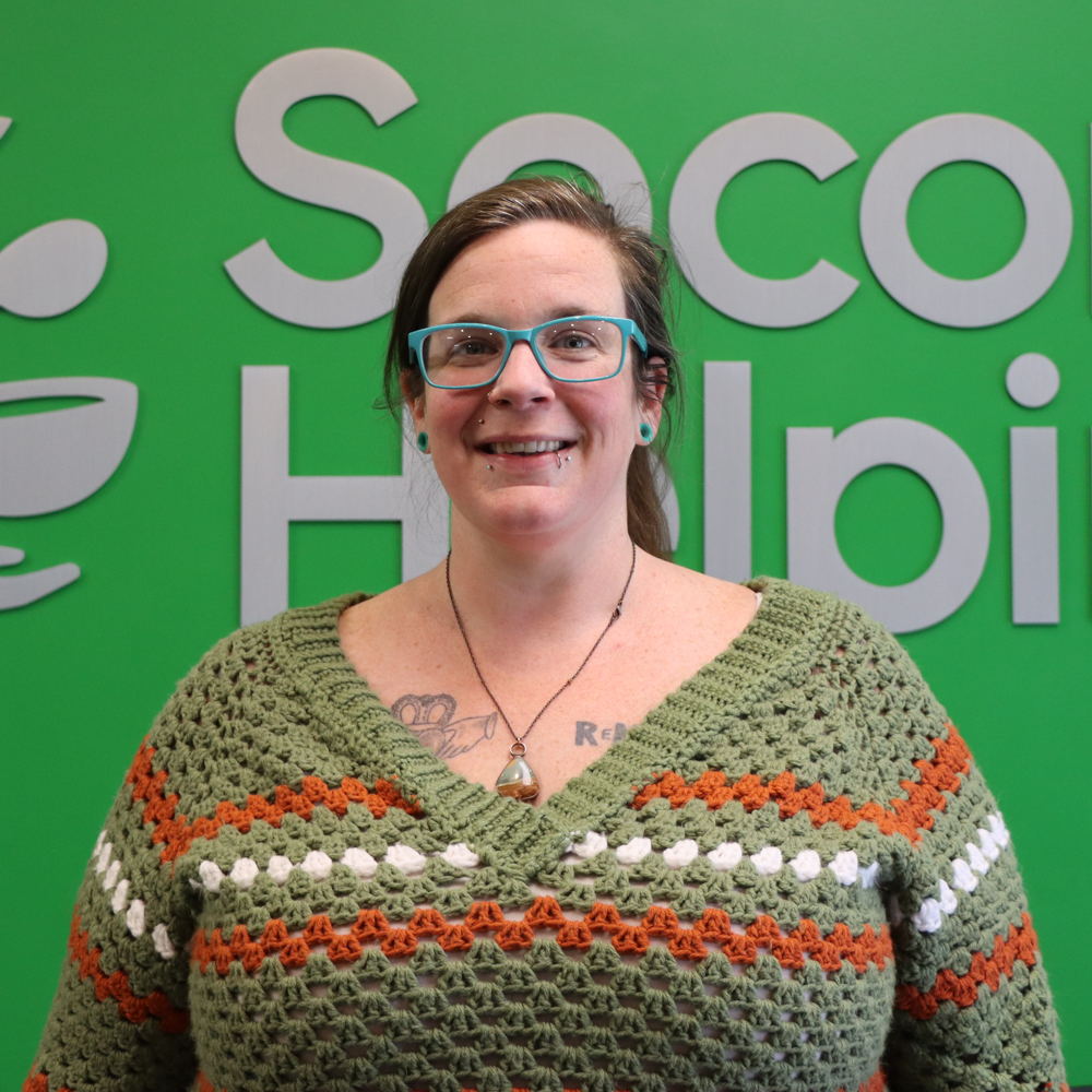 Becky with turquoise glasses and gauges wearing a crochet sweater