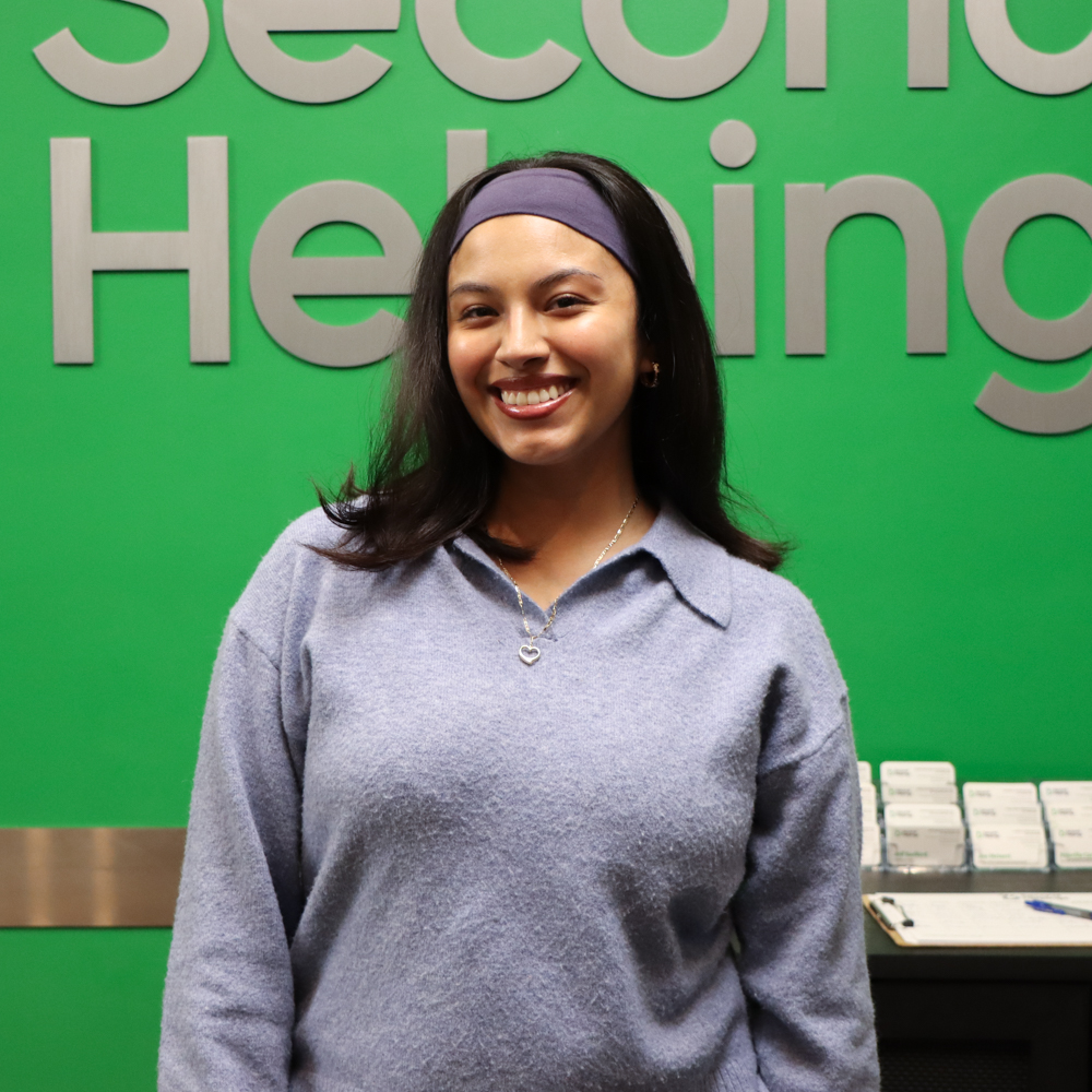 Priscilla wearing a blue headband and cool grey quarter-zip sweater