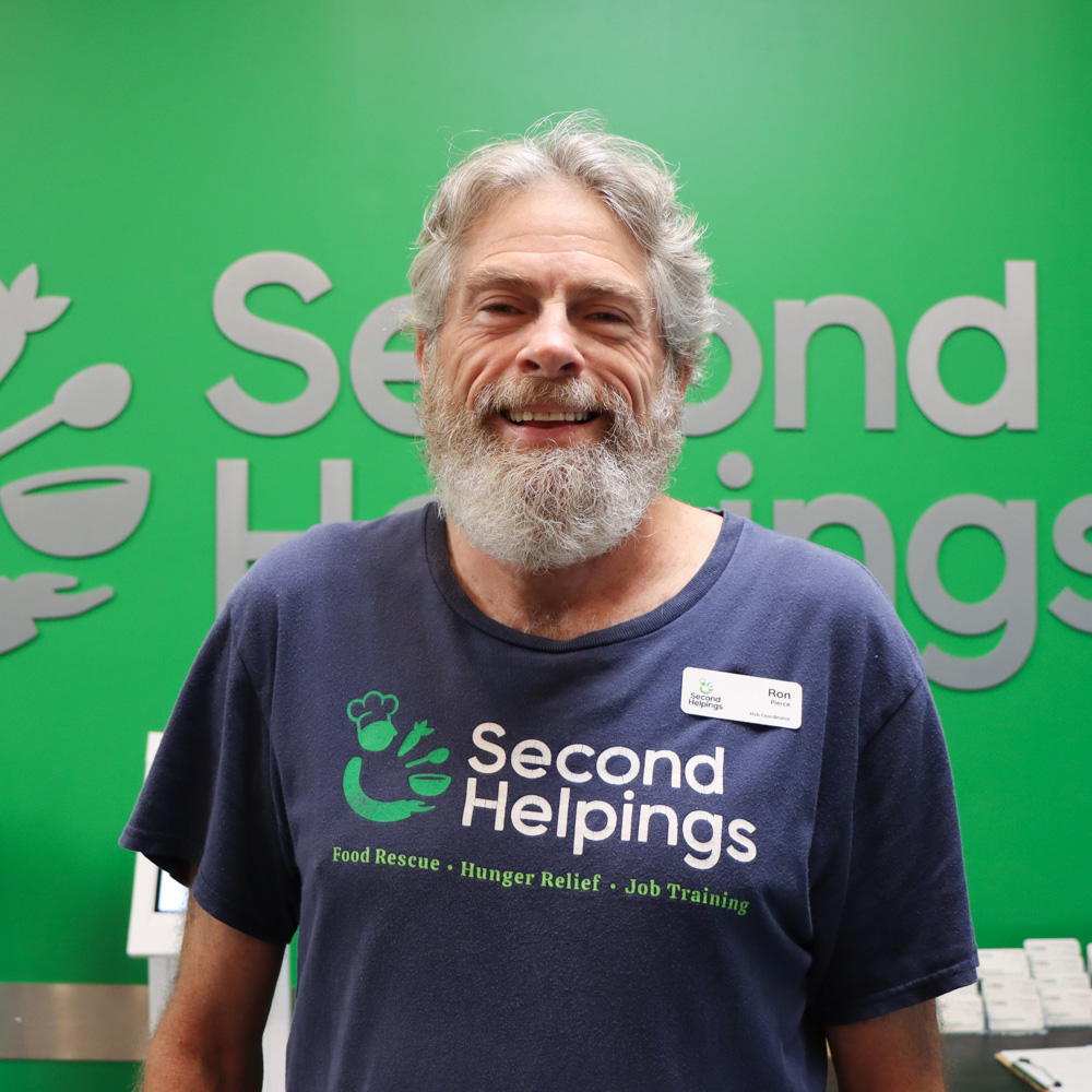 Ron smiling, wearing a blue Second Helpings shirt 